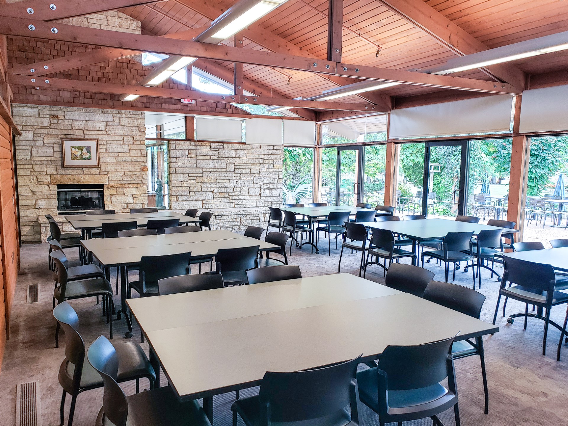 Speer Room with chairs around two tables pushed together. The right side of the room is a wall of windows; the ceiling is exposed wood and arches.