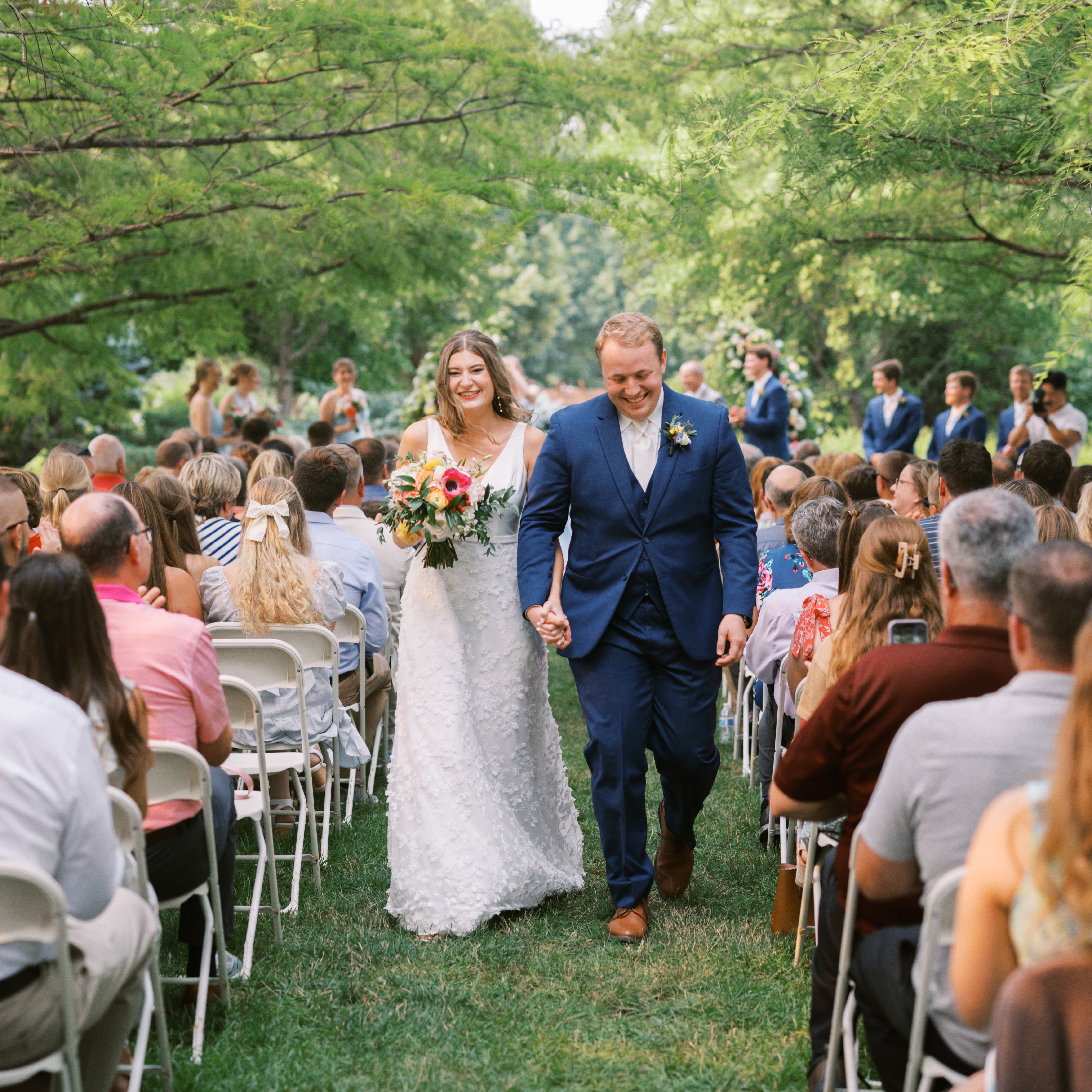 Bride and groom leaving wedding ceremony in forest