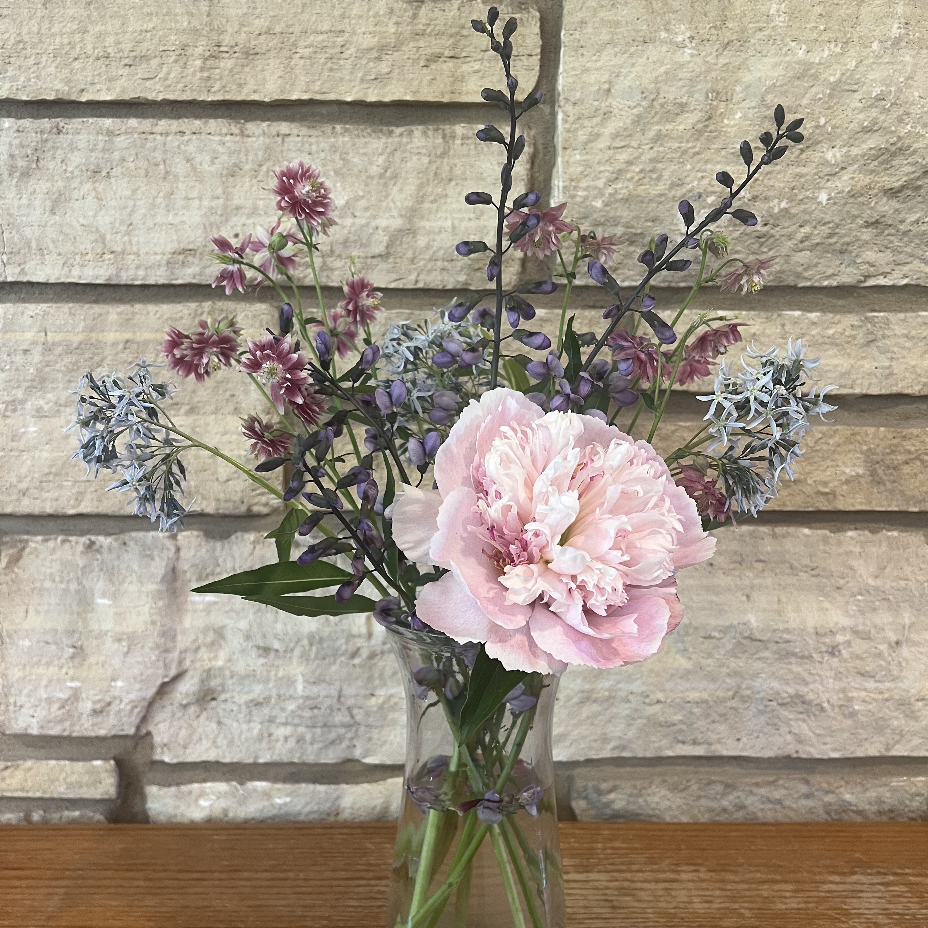 A bouquet of baptisia, eastern bluestar, columbine, and peonies