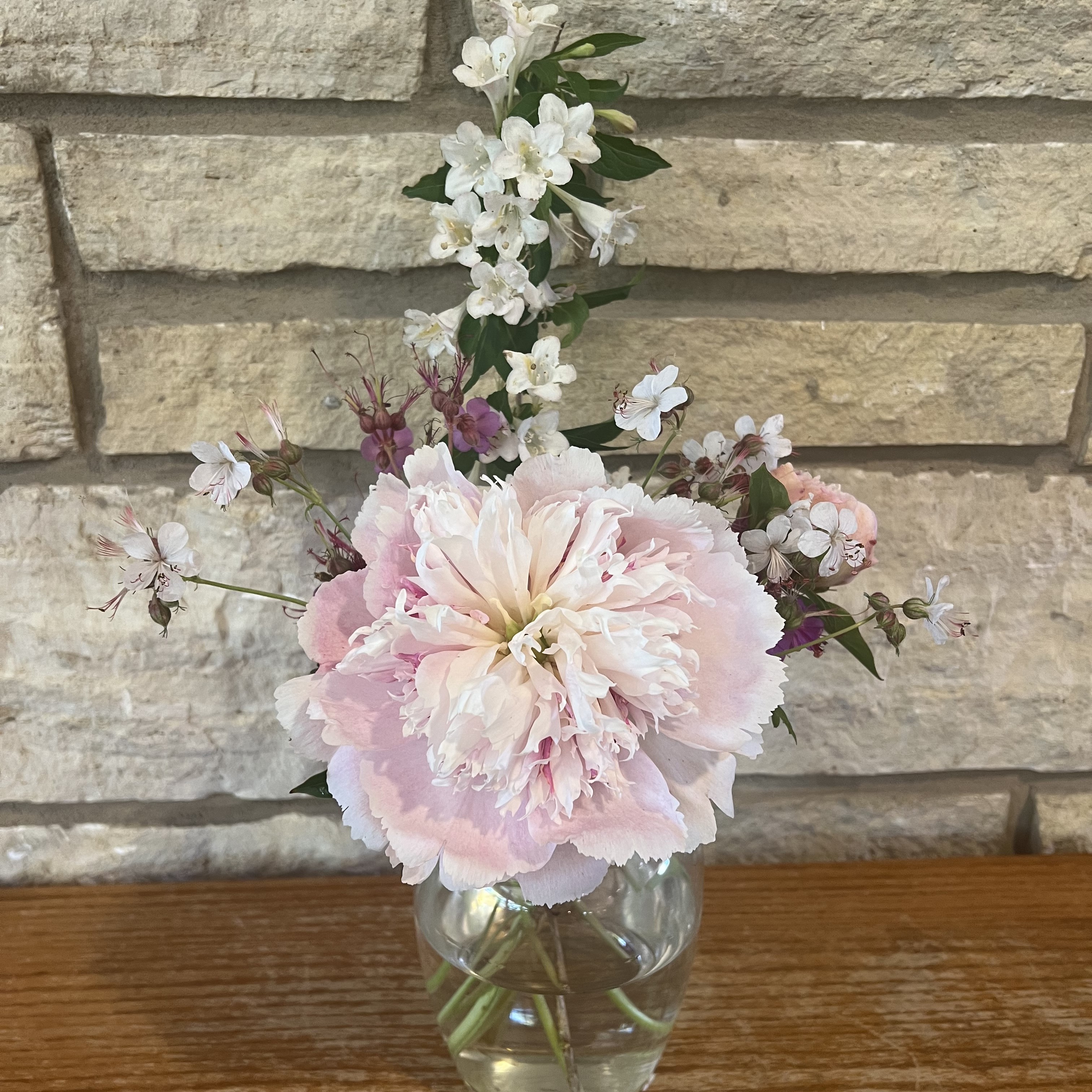 A bouquet with peonies, weigela, and geraniums