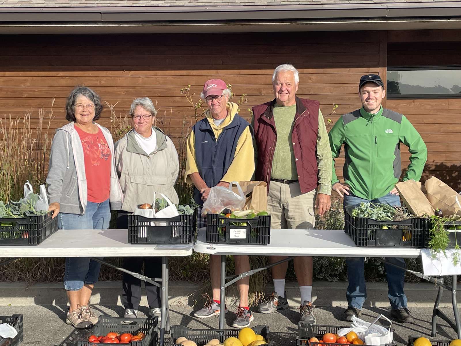 Five regular PAR volunteers stand behind produce collected, weighed, and about to be distributed to area food banks.