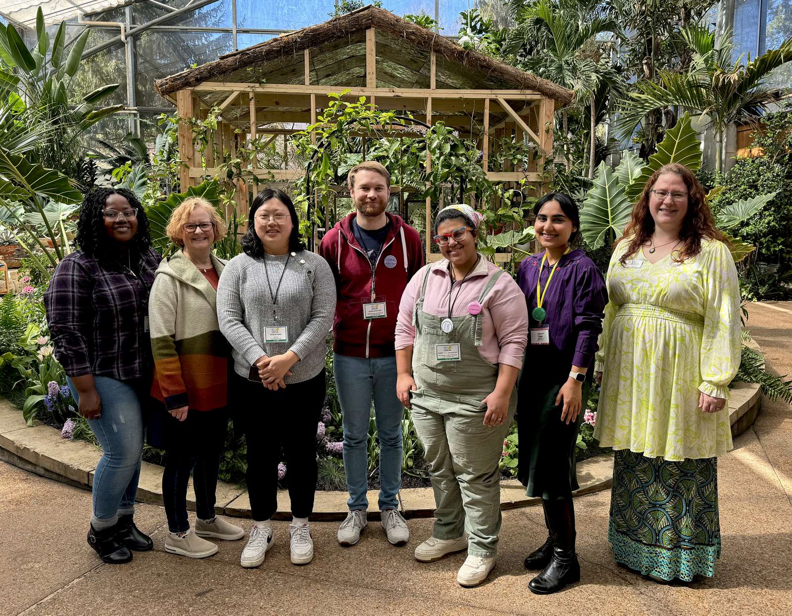 a group of people standing and smiling in Reiman Gardens' Hughes Conservatory